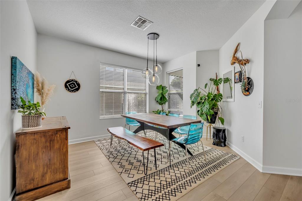 A living room features a tan sectional sofa, a dark wood media console, and a ceiling fan — 2329 NATOMA BLVD, MOUNT DORA, FL
