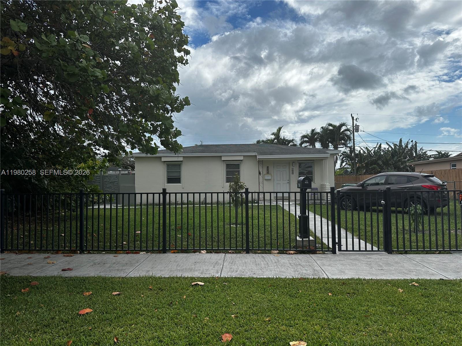A single-story house with a black metal fence and a driveway sits behind a sidewalk — 7540 SW 37th St, Miami FL 33155, MIAMI, FL
