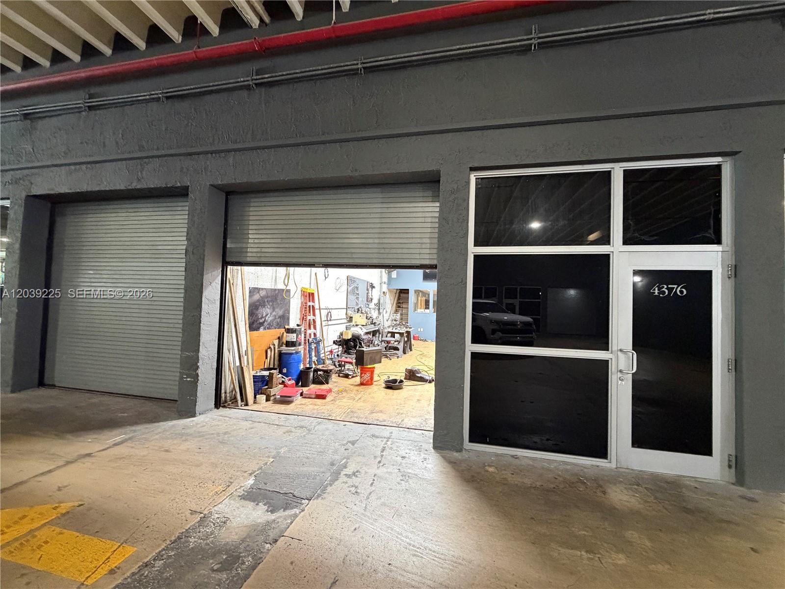 A commercial space features a roll-up door, a glass entry door, and a workshop interior — 4310 SW 73rd Ave # 4376, Miami FL 33155, MIAMI, FL