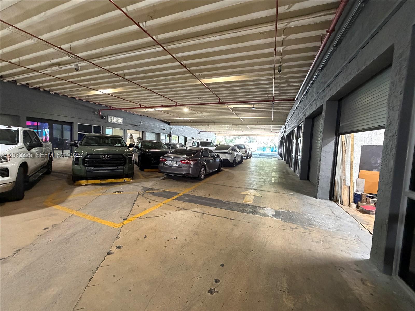 A covered parking area features a concrete floor, painted walls, and several parked vehicles — 4310 SW 73rd Ave # 4376, Miami FL 33155, MIAMI, FL