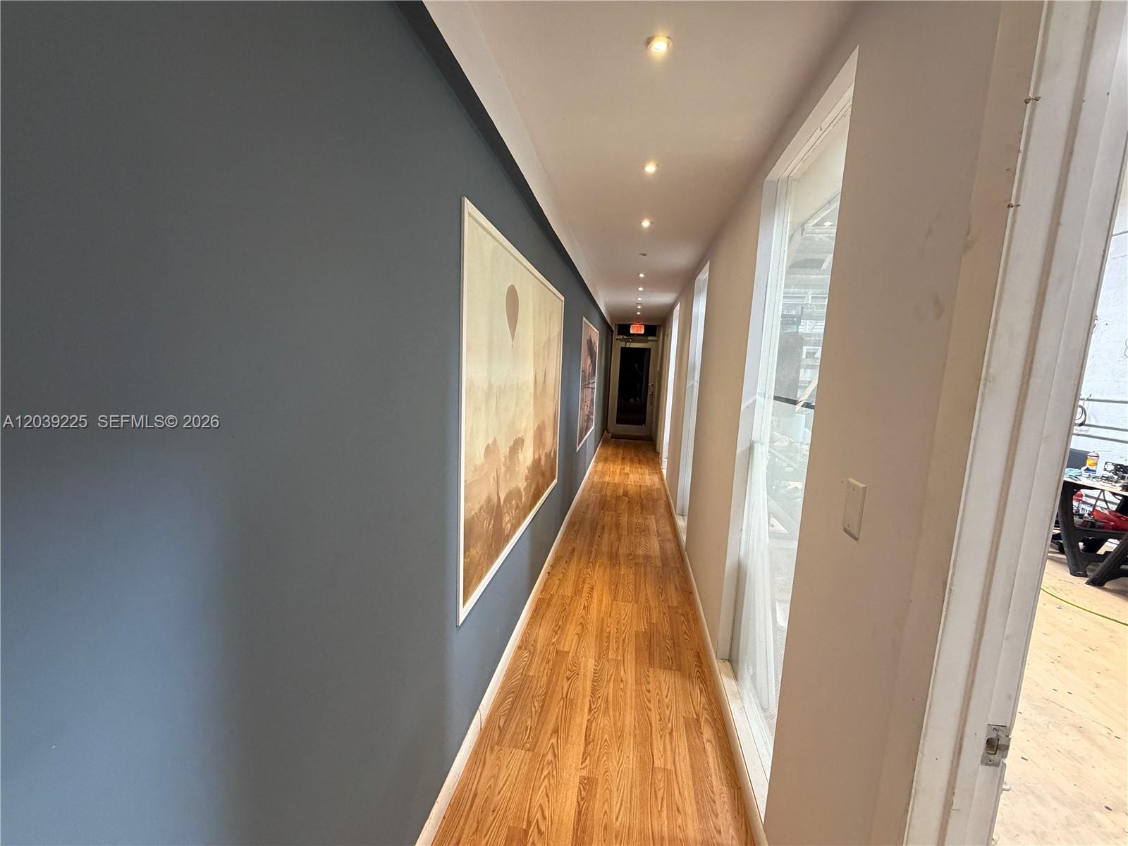 A narrow hallway features wood-look flooring, a dark blue accent wall, and recessed ceiling lighting — 4310 SW 73rd Ave # 4376, Miami FL 33155, MIAMI, FL