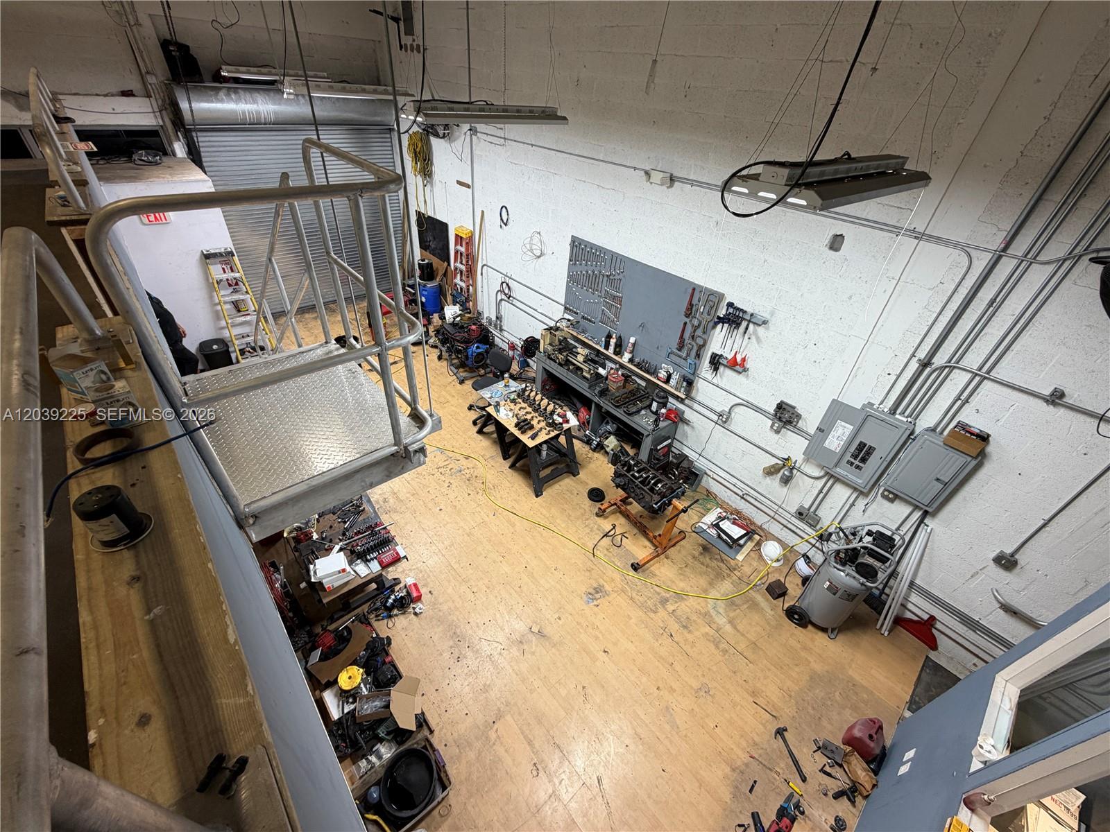 An elevated view of a workshop featuring a metal mezzanine, workbench, and engine parts — 4310 SW 73rd Ave # 4376, Miami FL 33155, MIAMI, FL
