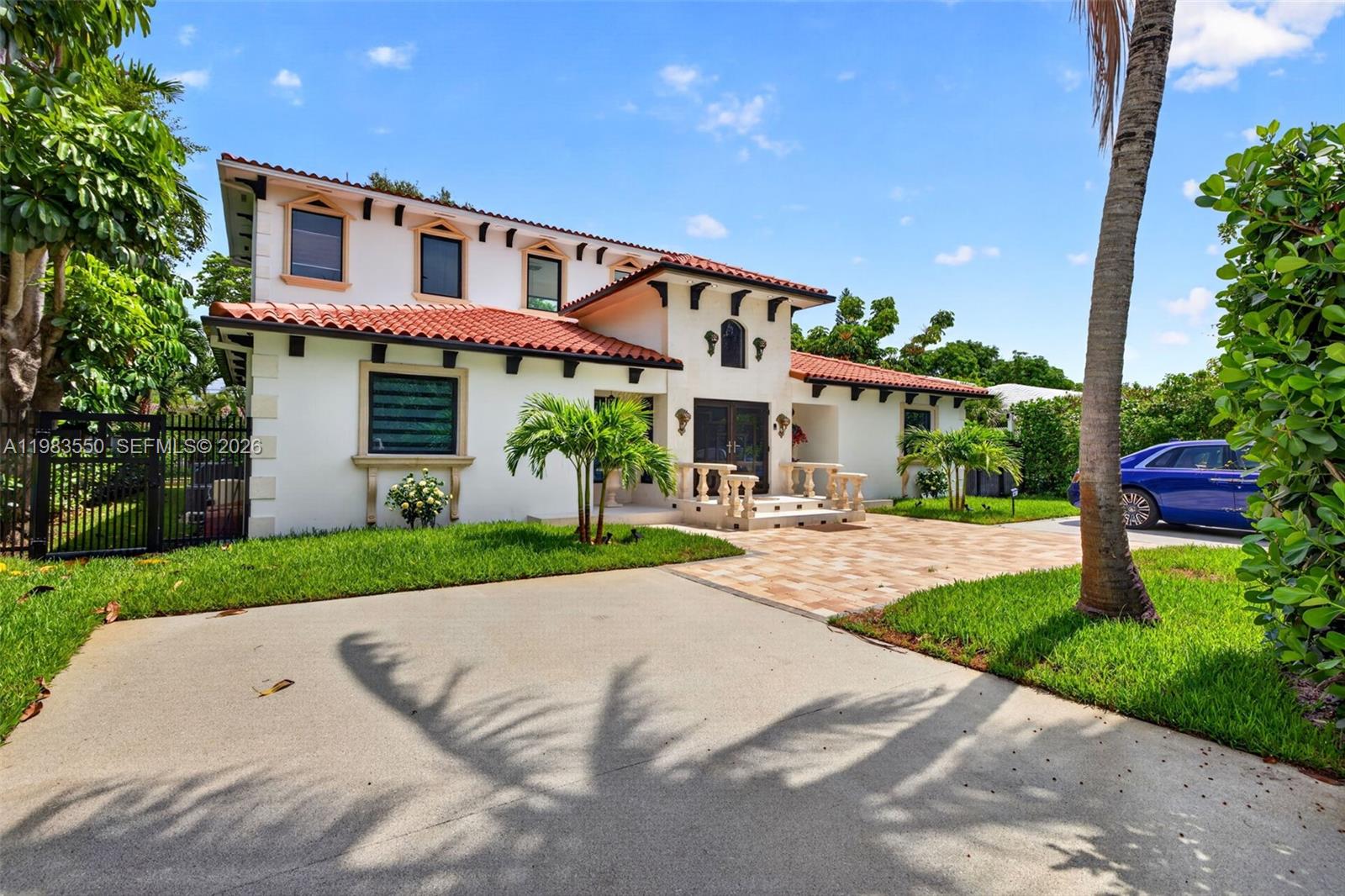 A two-story Mediterranean-style house with a red tile roof and a paved driveway — 941 NE 119th St, Biscayne Park FL 33161, BISCAYNE PARK, FL