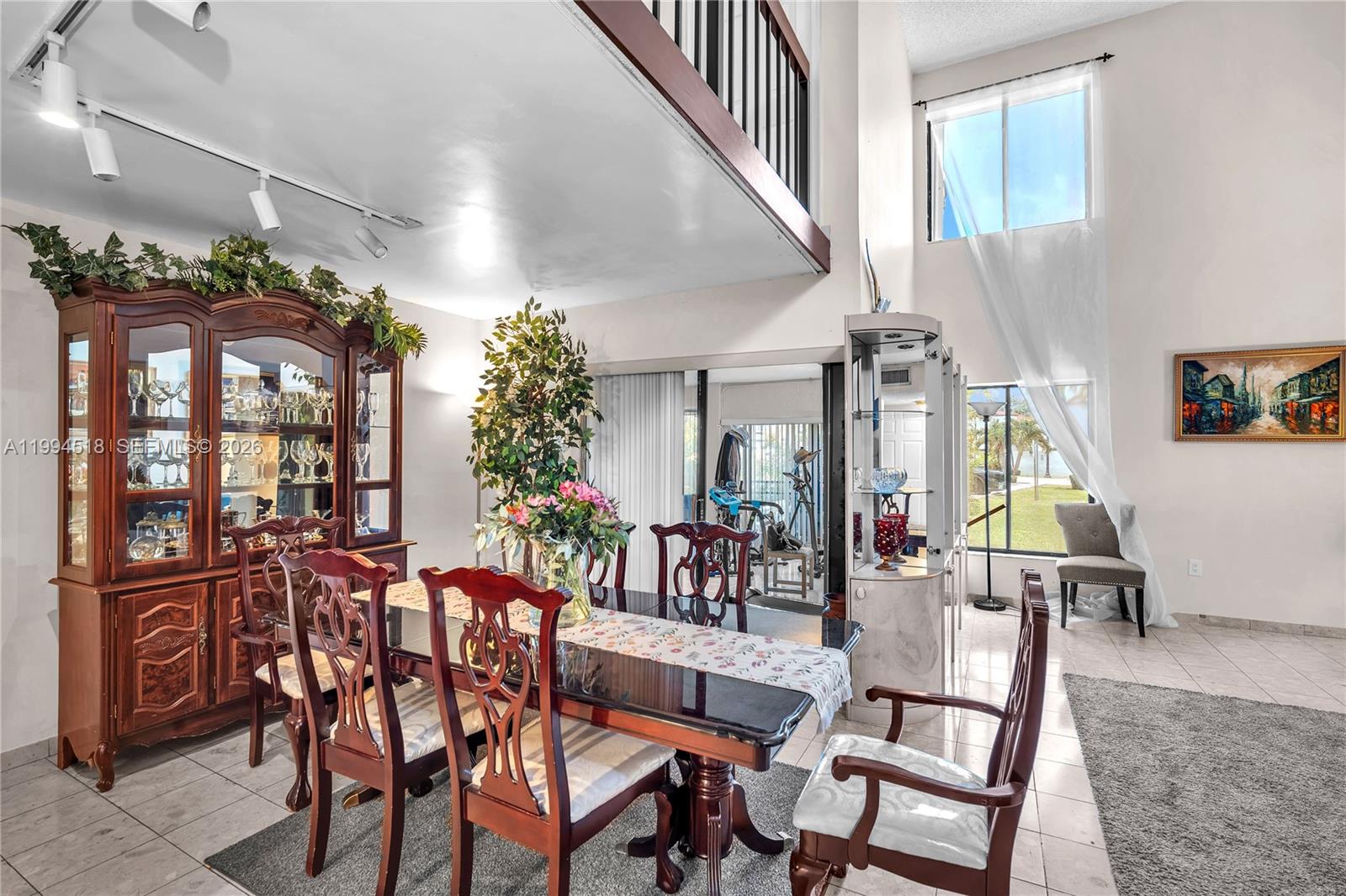 A dining room with a wooden hutch, a table with chairs, and a high ceiling — 1321 SW 124th Ct # A, Miami FL 33184, MIAMI, FL