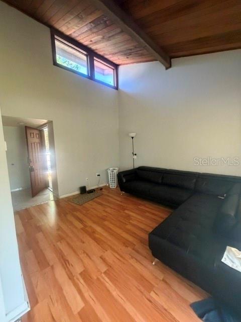 A living room features a vaulted wood-paneled ceiling, hardwood floors, and a black sectional sofa — 5981 WINDHOVER DRIVE UNIT A10, ORLANDO, FL