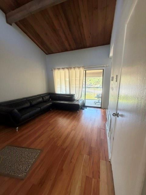 A living room features a black sectional sofa, wood flooring, and a vaulted wood-paneled ceiling — 5981 WINDHOVER DRIVE UNIT A10, ORLANDO, FL