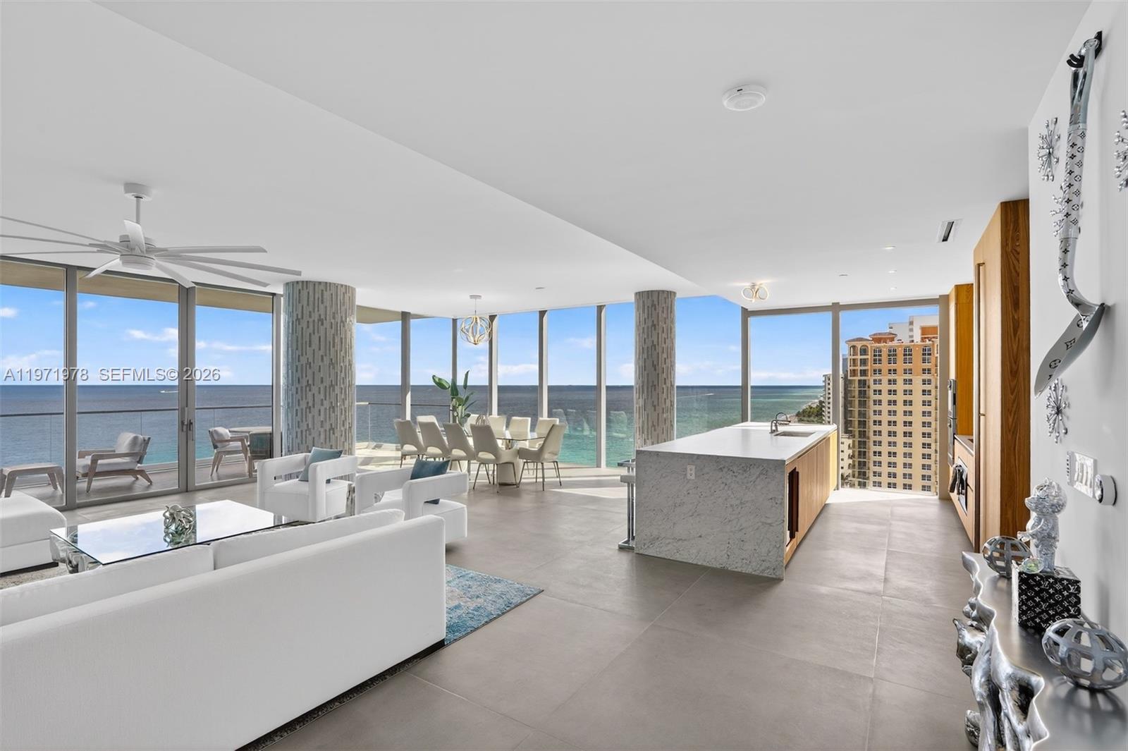 A modern open-concept living and dining area features floor-to-ceiling windows with ocean views — 2000 S Ocean Dr # 14B, Hallandale Beach FL 33009, HALLANDALE BEACH, FL