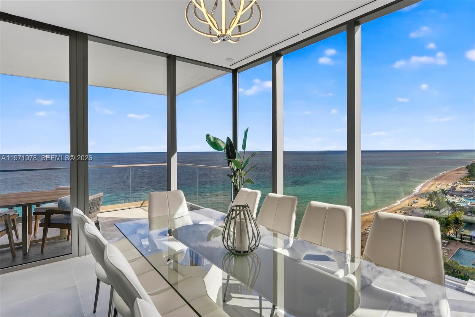 A dining area with a glass table and floor-to-ceiling windows overlooking the ocean — 2000 S Ocean Dr # 14B, Hallandale Beach FL 33009, HALLANDALE BEACH, FL