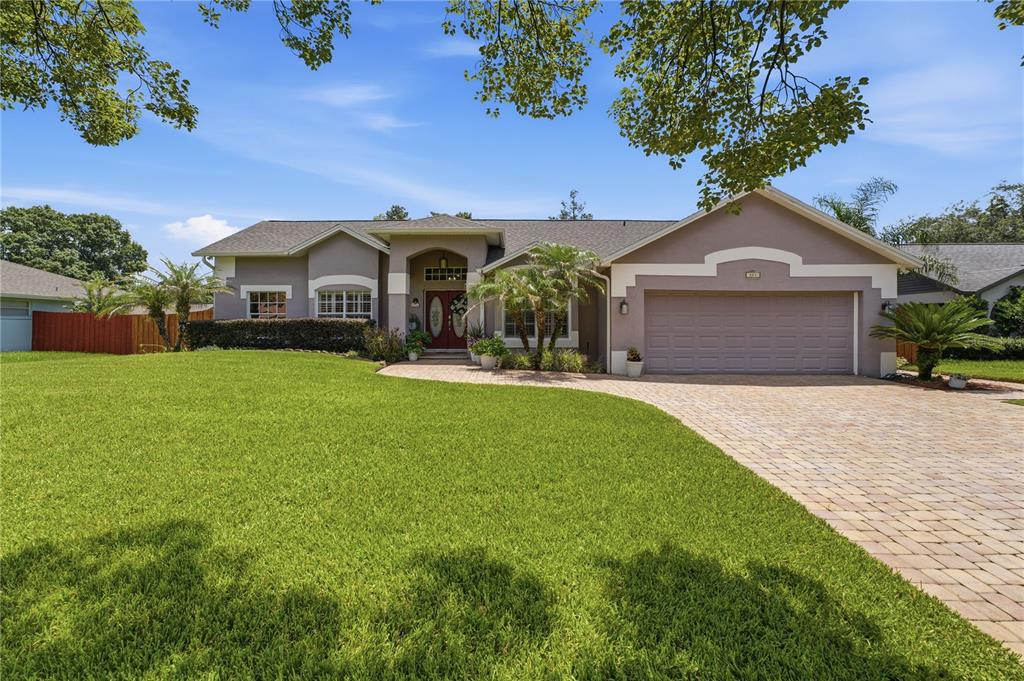 A single-story house with a paved driveway, a two-car garage, and a large front lawn — 803 PINE MEADOWS ROAD, ORLANDO, FL