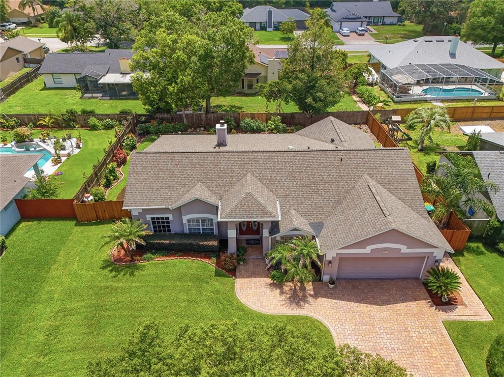 An aerial view of a single-story suburban house with a paved driveway and backyard pool — 803 PINE MEADOWS ROAD, ORLANDO, FL