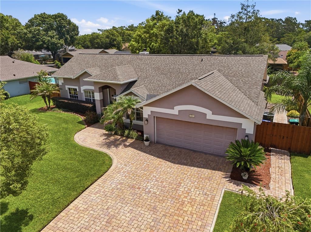 An aerial view of a single-story house with a paved driveway and a green lawn — 803 PINE MEADOWS ROAD, ORLANDO, FL