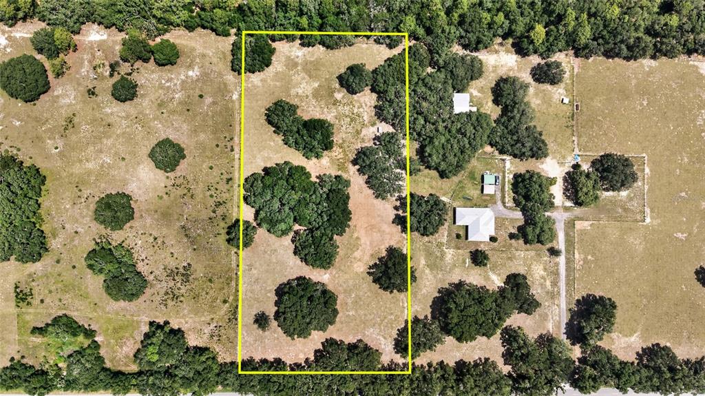 An aerial view shows a rectangular parcel of land outlined in yellow with scattered trees — 2611 E STAGE COACH TRAIL, INVERNESS, FL