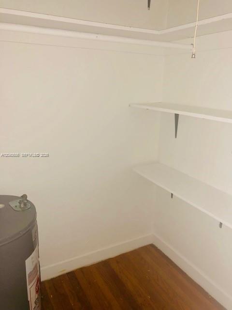 A closet with wooden floors, white walls, two wall-mounted shelves, and a water heater — 1008 E Ponce De Leon Blvd # 3, Coral Gables FL 33134, CORAL GABLES, FL