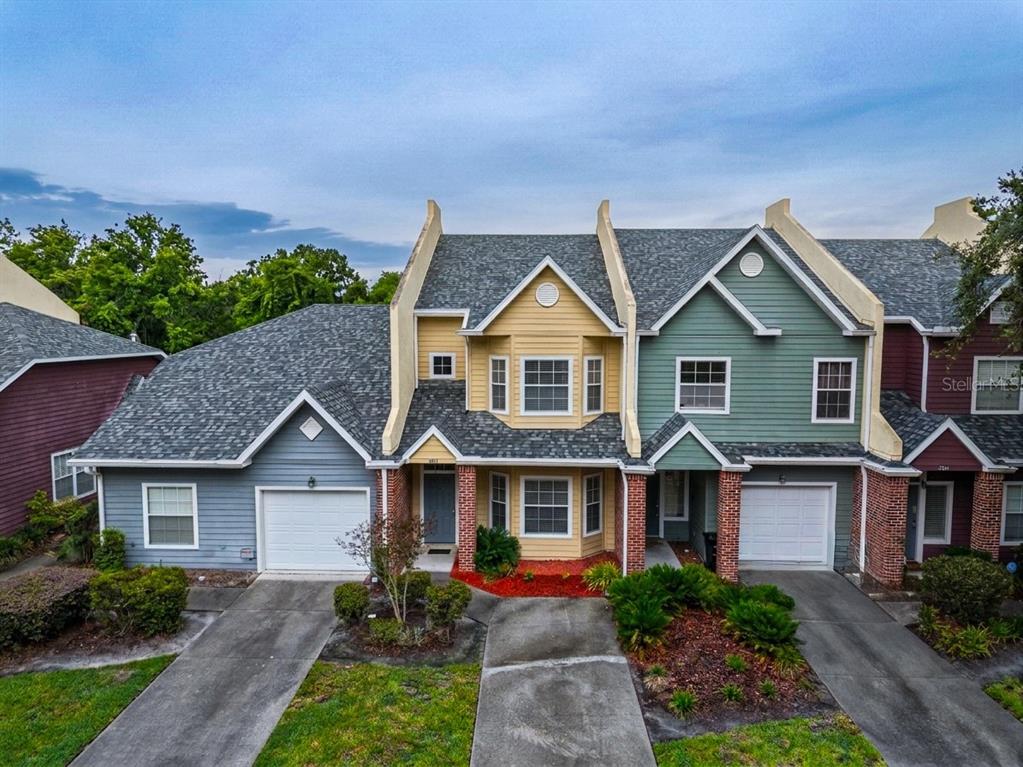 An exterior view of a multi-unit townhouse complex with varied siding colors and attached garages — 4946 NW 1ST PLACE, GAINESVILLE, FL