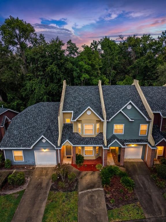 An aerial view of a multi-unit townhouse complex with attached garages and wooded surroundings — 4946 NW 1ST PLACE, GAINESVILLE, FL