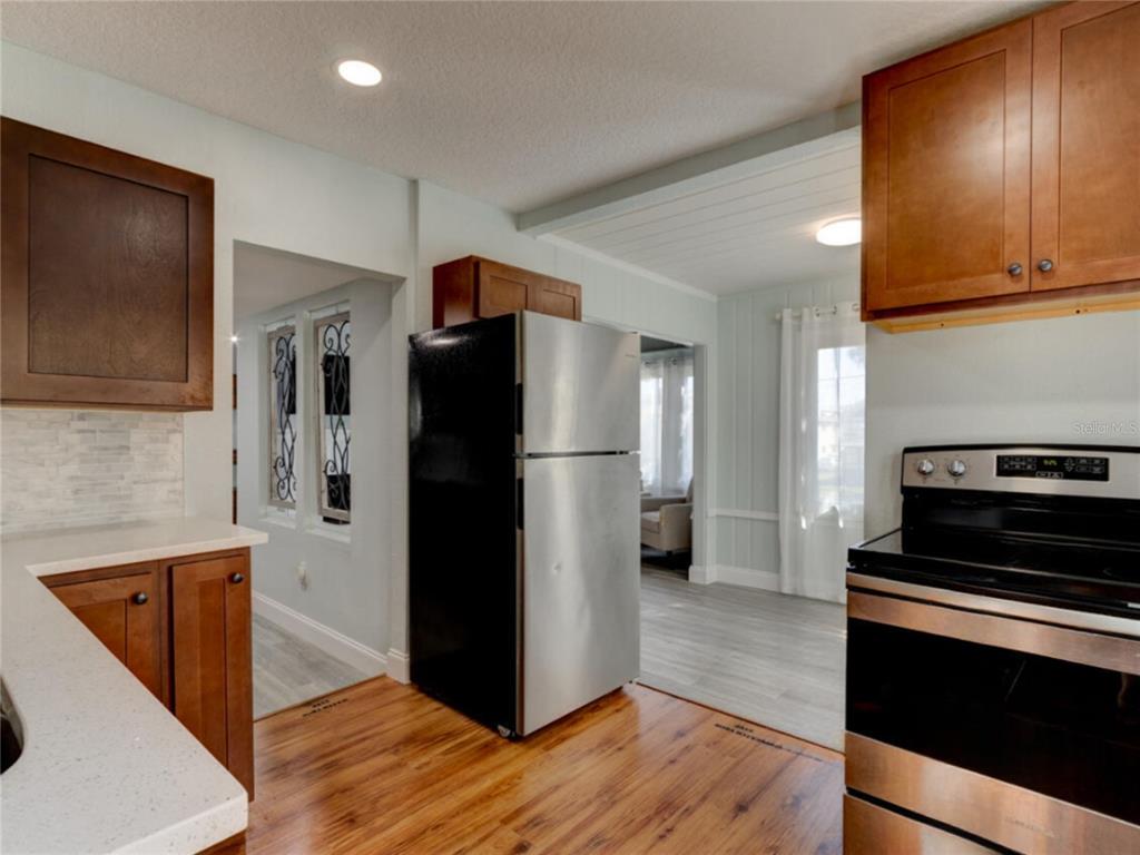 A kitchen features wood cabinets, stainless steel appliances, and light wood flooring — 425 N OLEANDER AVENUE, DAYTONA BEACH, FL