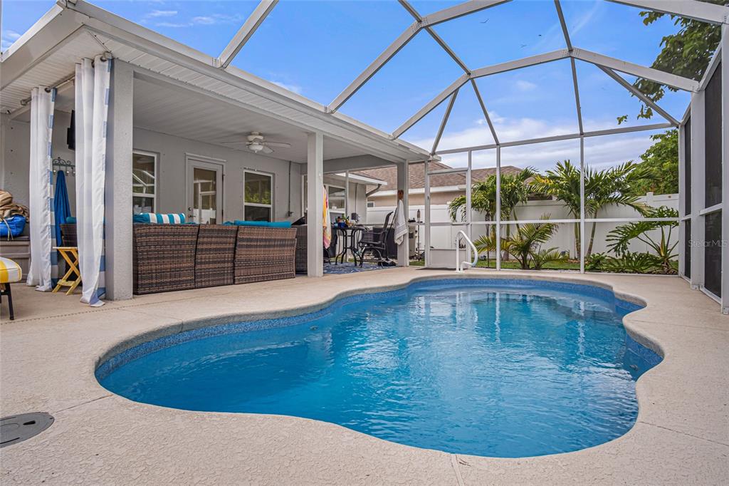 A screened-in patio features a swimming pool, outdoor seating, and a covered living area — 771 TUPELO CIRCLE, COCOA, FL