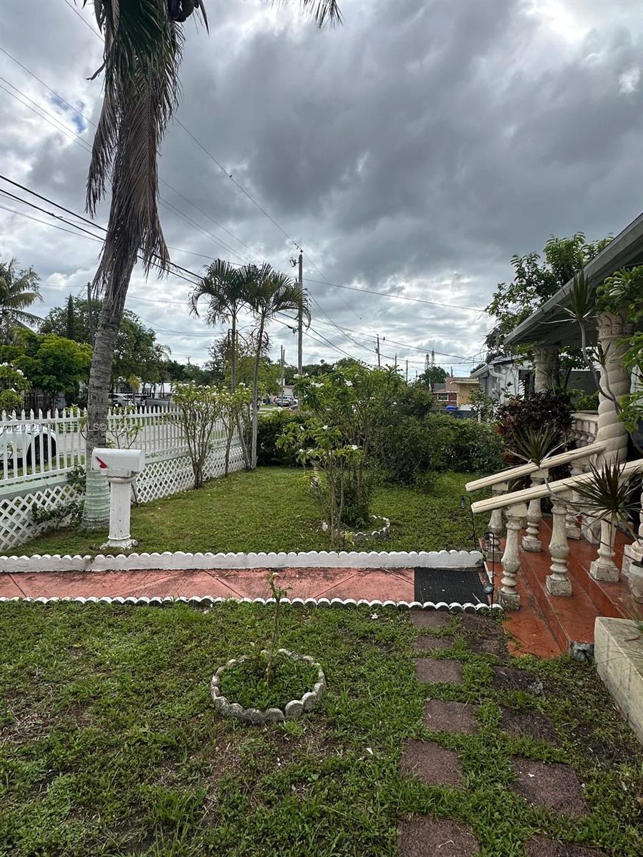 A front yard features a white fence, a mailbox, palm trees, and a porch entrance — 1376 NW 45th St, Miami FL 33142, MIAMI, FL