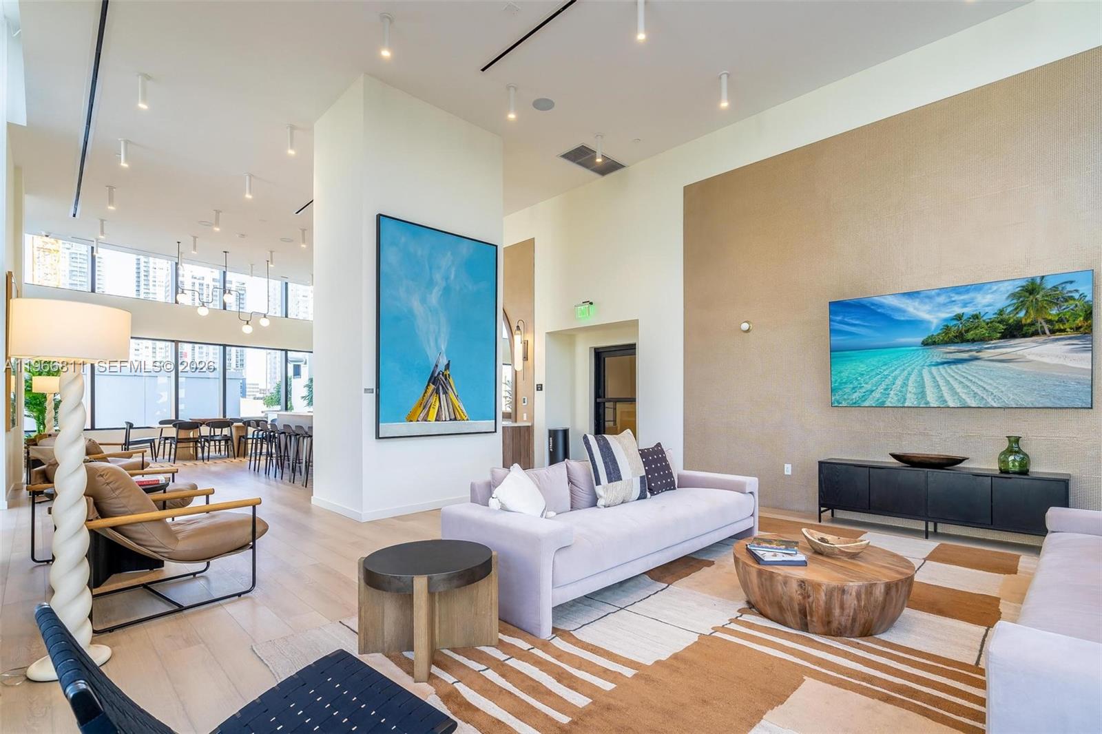 A modern living room features a large sofa, a wooden coffee table, and wall-mounted television — 225 N Miami Ave # 3307, Miami FL 33128, MIAMI, FL