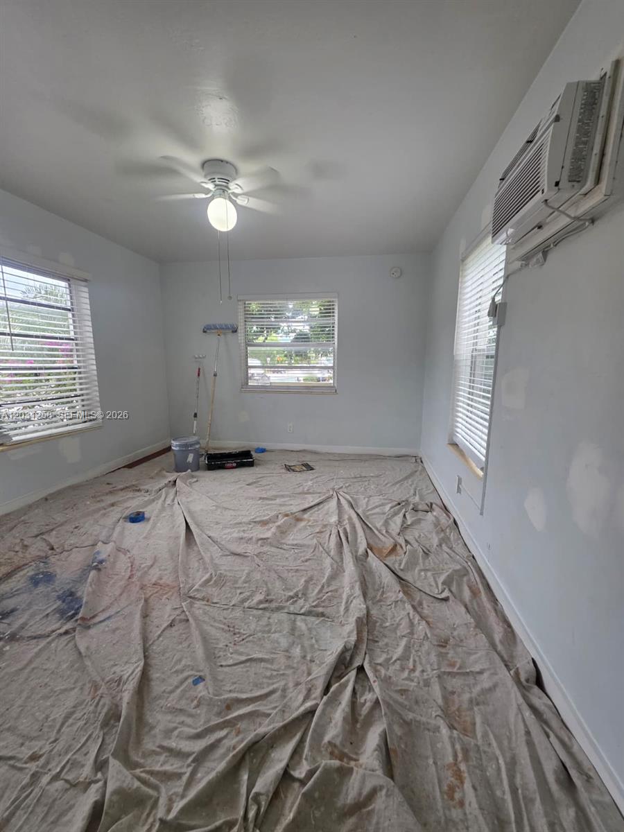 An empty room under renovation features a ceiling fan, window blinds, and a drop cloth — 8024 Harding Ave # 1A, Miami Beach FL 33141, MIAMI BEACH, FL