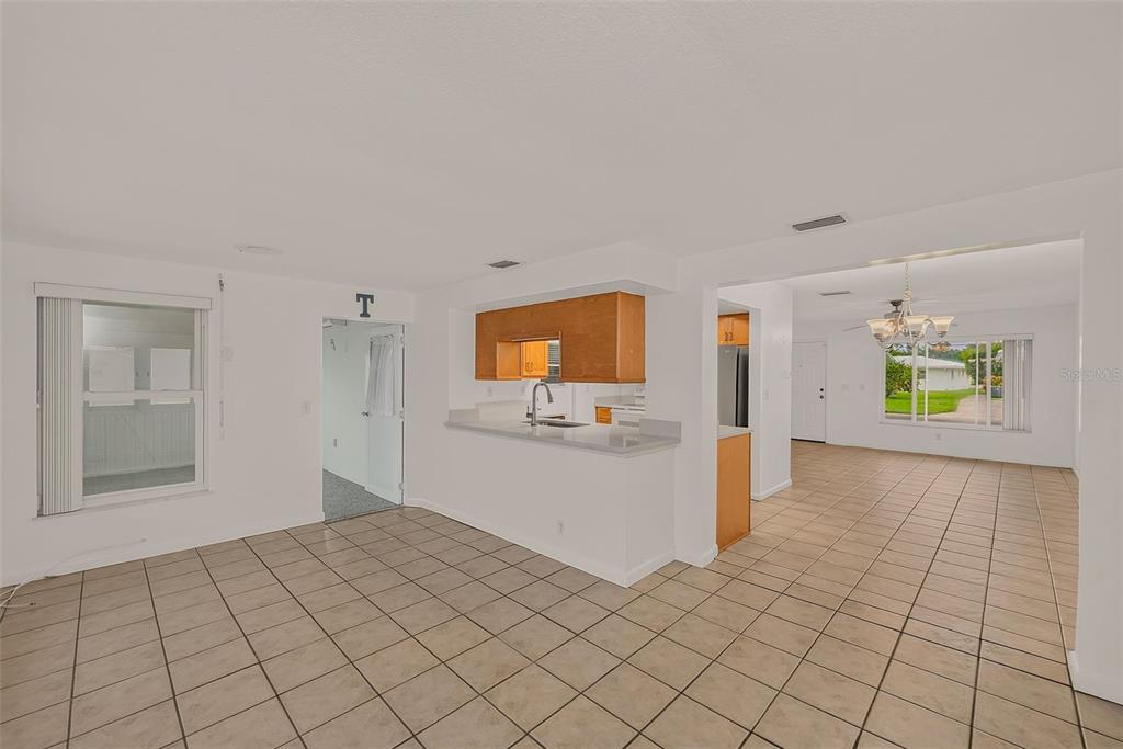 A kitchen with wooden cabinets and a breakfast bar overlooks a tiled dining area — 14144 87TH AVENUE, SEMINOLE, FL