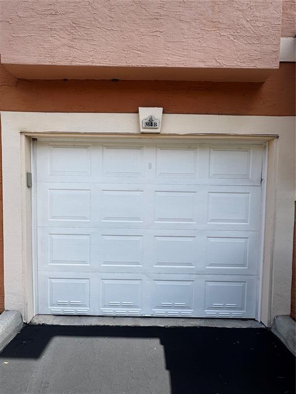 A white sectional garage door is set into a tan stucco exterior wall — 5000 CULBREATH KEY WAY UNIT 3-301, TAMPA, FL