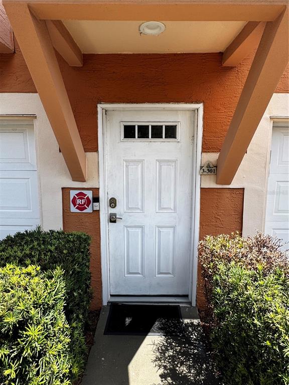 A white front door with a small window sits under a brown overhang — 5000 CULBREATH KEY WAY UNIT 3-301, TAMPA, FL