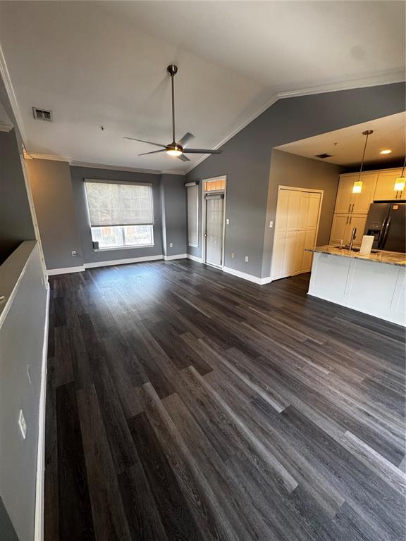 An open-concept living area features gray walls, dark wood-look flooring, and a kitchen island — 5000 CULBREATH KEY WAY UNIT 3-301, TAMPA, FL