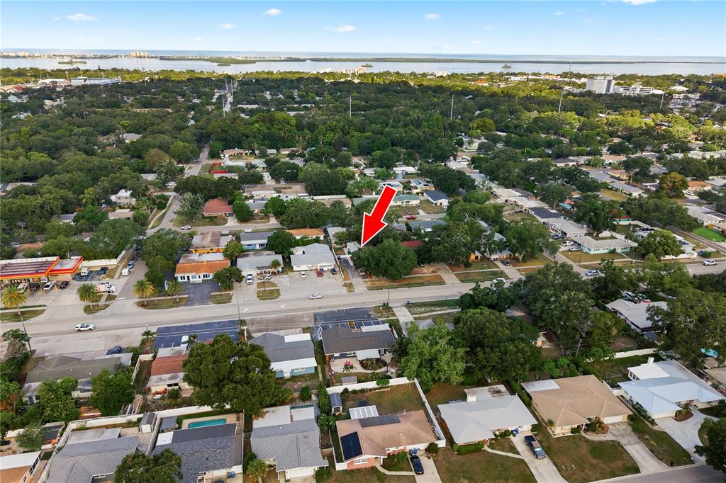 An aerial view shows a residential neighborhood with a red arrow pointing toward a house — 536 PATRICIA AVENUE, DUNEDIN, FL