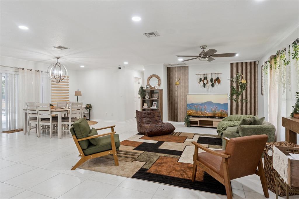 A living and dining area features white tile floors, wood slat wall accents, and modern furniture — 1756 TANGLE WOOD DRIVE, KISSIMMEE, FL