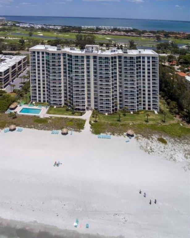An aerial view of a tall beachfront condominium building with a pool and sandy beach — 2425 GULF OF MEXICO DRIVE UNIT 11F, LONGBOAT KEY, FL