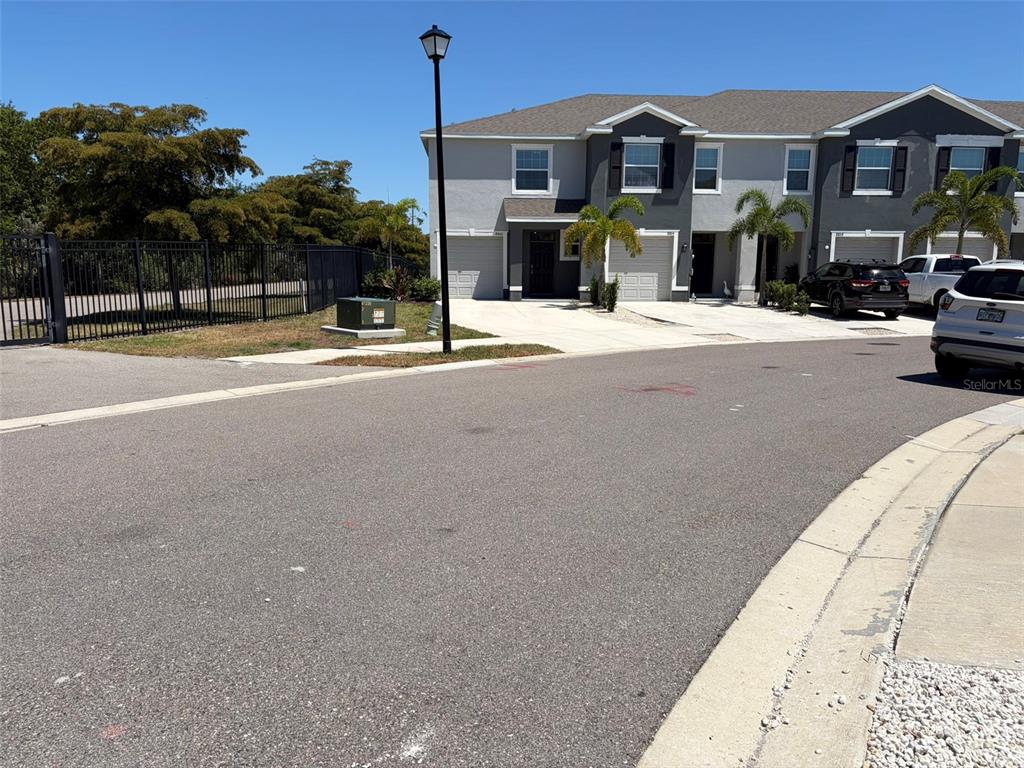 A street view shows a two-story townhouse complex with a paved driveway and palm trees — 8860 MILESTONE DRIVE, SARASOTA, FL