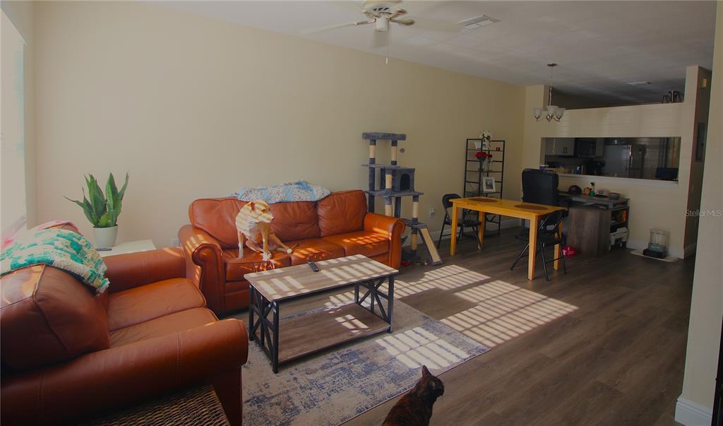 A living room with leather furniture, a coffee table, and a dining area in the background — 12369 BERKELEY SQUARE DRIVE, TAMPA, FL