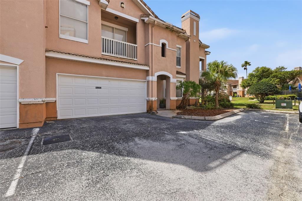 A tan two-story townhouse with a white garage door and a second-floor balcony — 10504 VILLA VIEW CIRCLE, TAMPA, FL