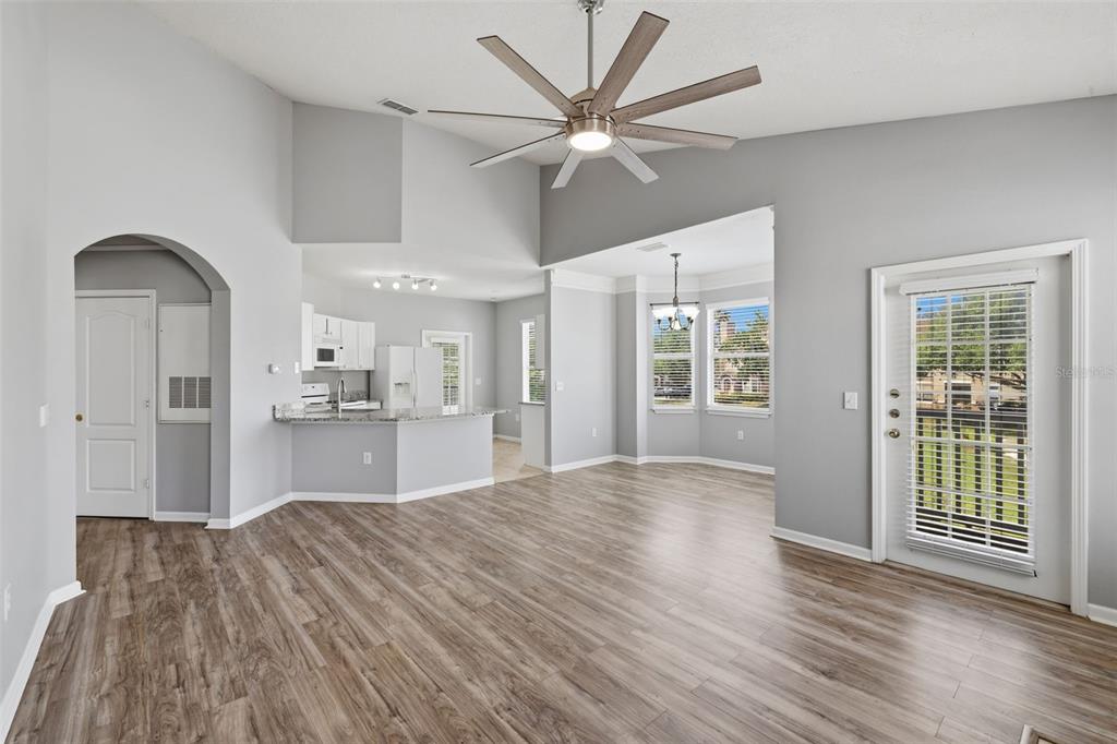A living room with light gray walls, wood-look flooring, a ceiling fan, and an open kitchen — 10504 VILLA VIEW CIRCLE, TAMPA, FL