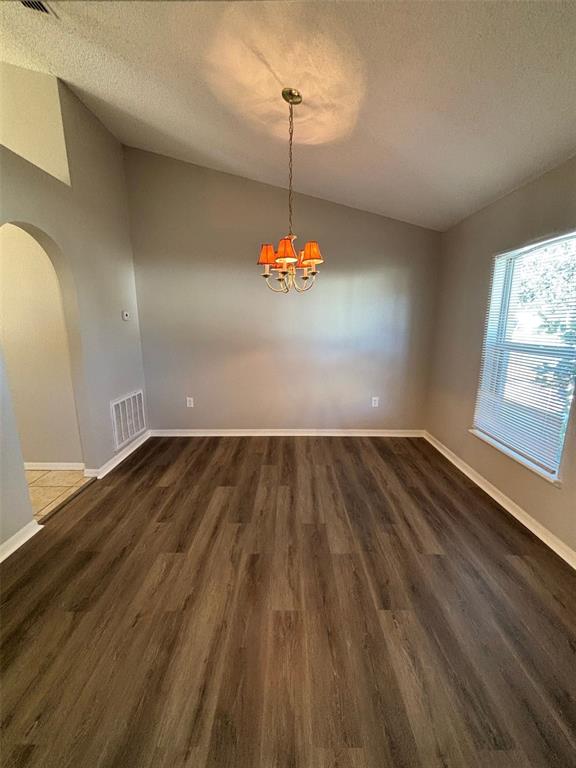 A dining room with wood-look flooring, a vaulted ceiling, and a hanging chandelier — 1613 SAIL DRIVE, POINCIANA, FL