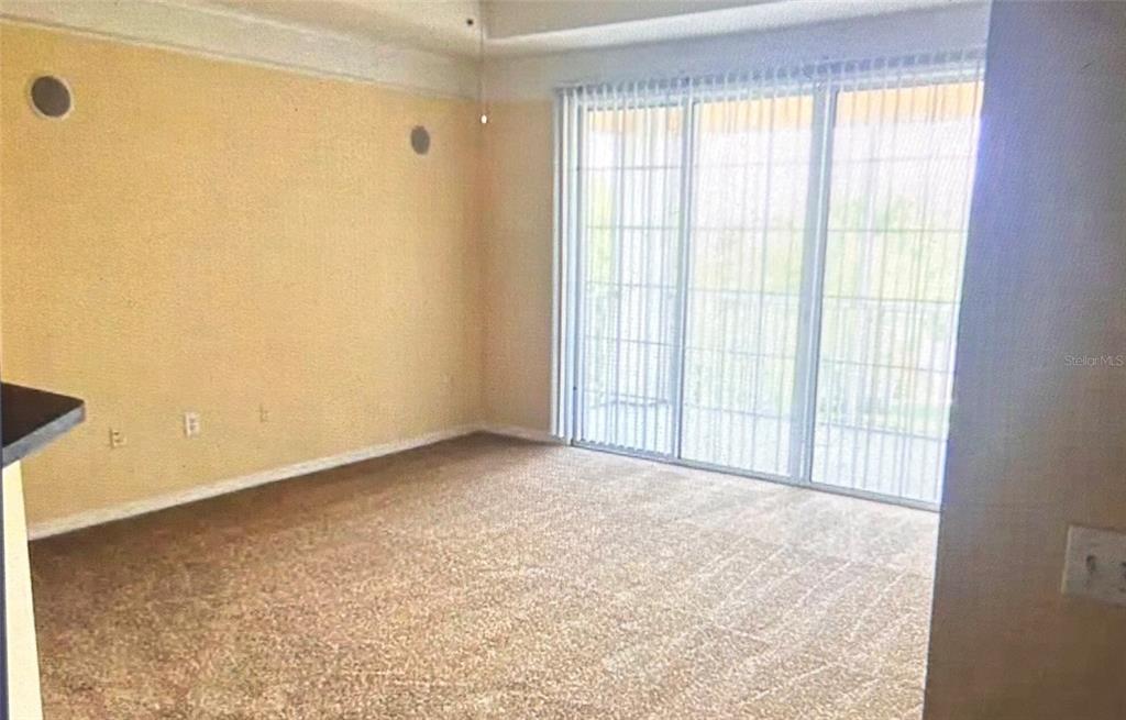 A kitchen features white cabinets, stainless steel appliances, a subway tile backsplash, and marble-look flooring — 6412 QUEENS BOROUGH AVENUE UNIT 315, ORLANDO, FL