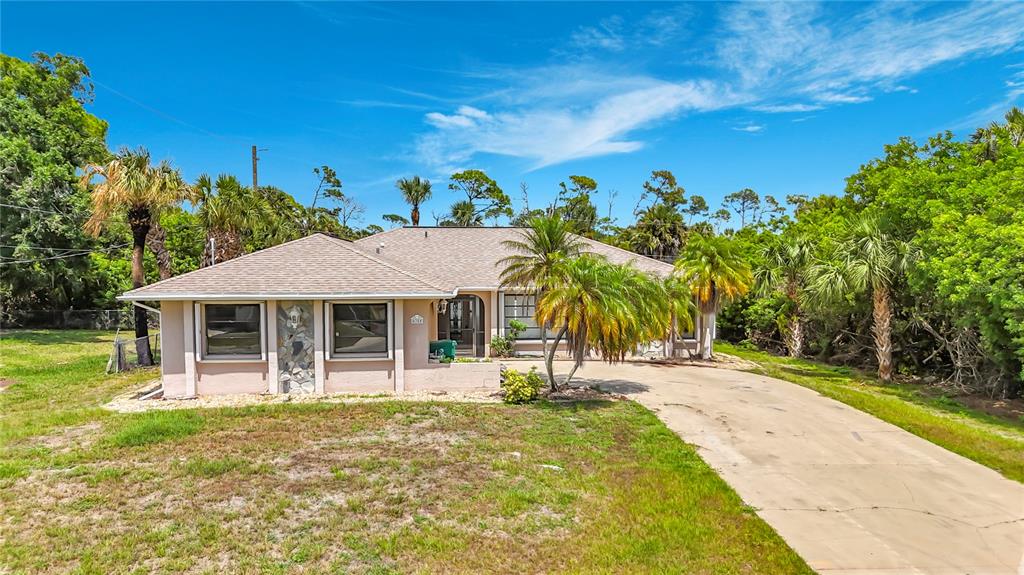 A single-story house with a beige exterior, stone accents, and a concrete driveway — 4354 BOGGS STREET, PORT CHARLOTTE, FL