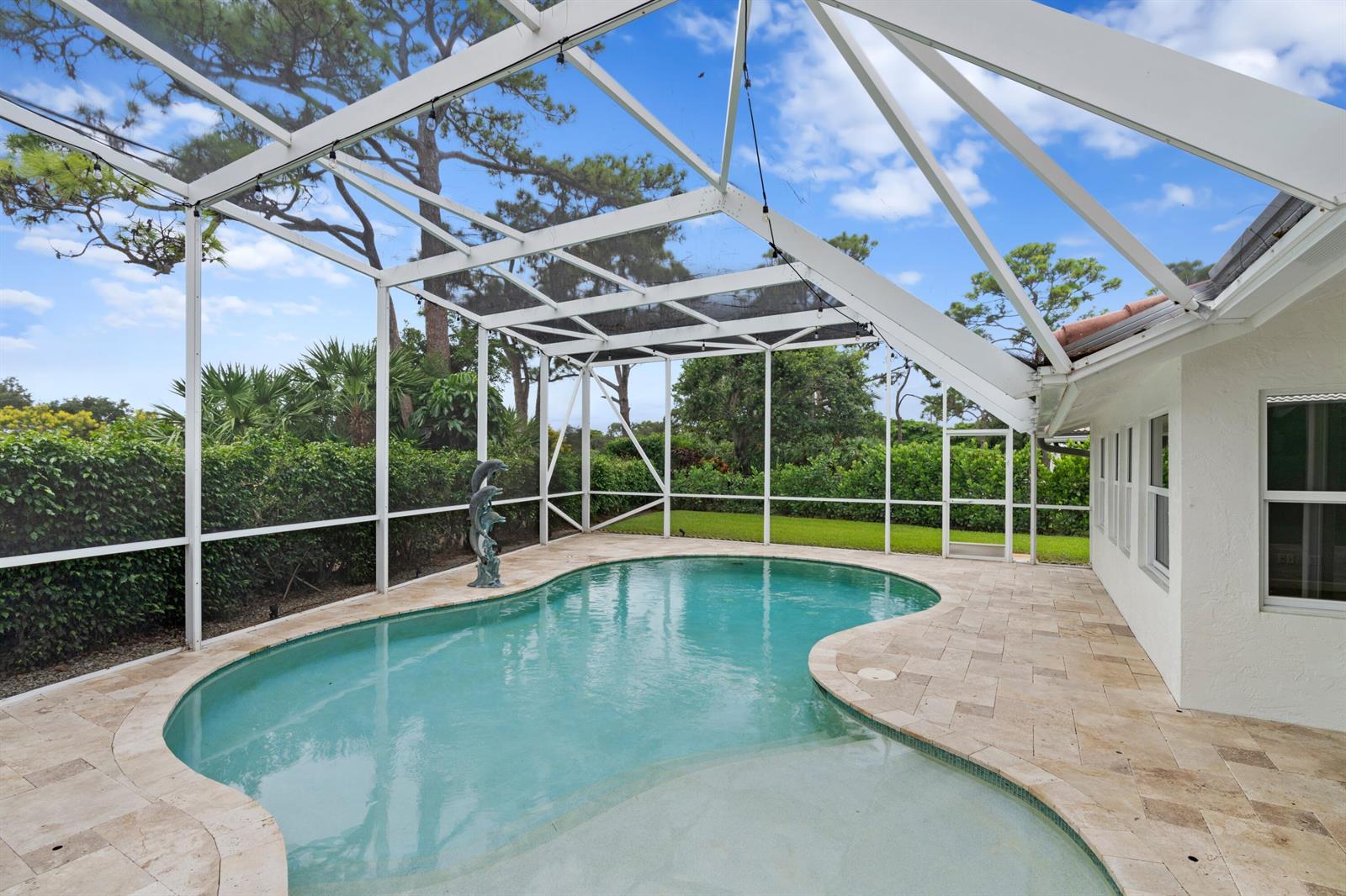 A swimming pool with a stone deck is enclosed by a white screen cage — 925 Foxpointe Circle, Delray Beach FL 33445, DELRAY BEACH, FL
