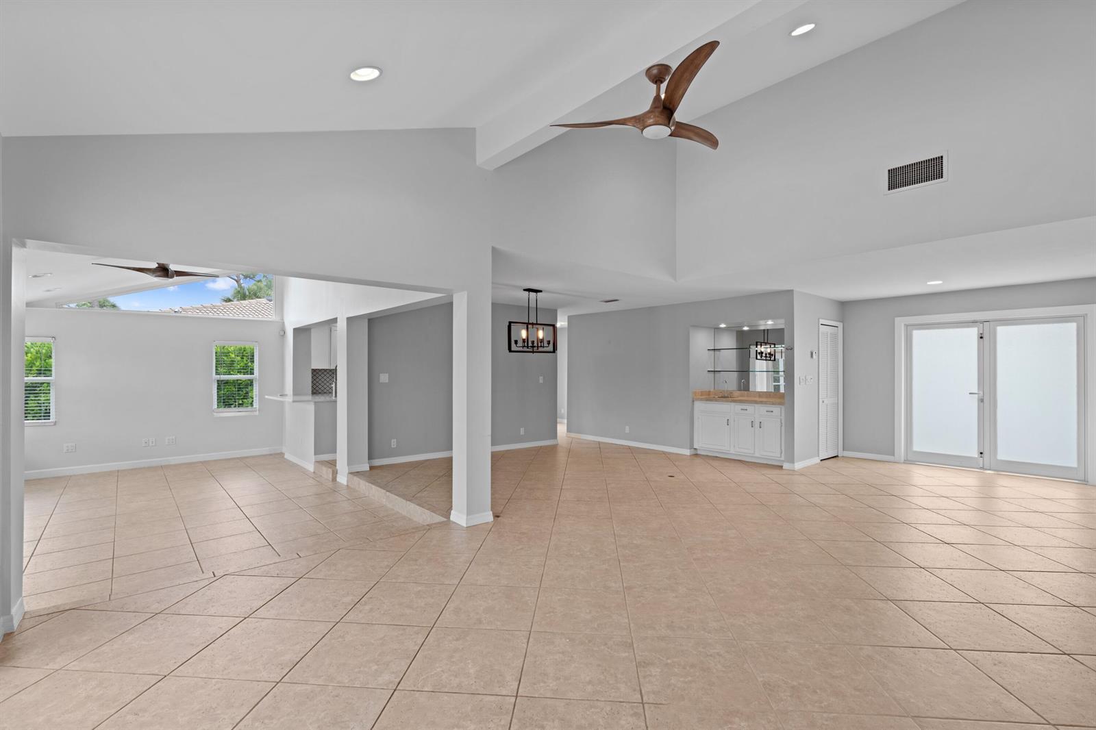 A spacious living area features vaulted ceilings, tile flooring, a wet bar, and ceiling fans — 925 Foxpointe Circle, Delray Beach FL 33445, DELRAY BEACH, FL