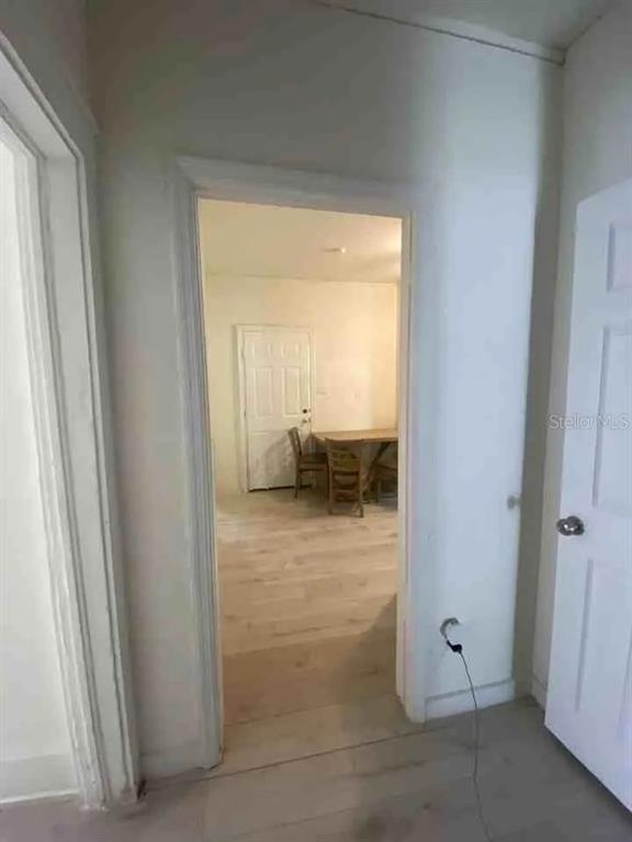 A view through a doorway into a dining area with light-colored wood flooring — 4427 RALEIGHT STREET, ORLANDO, FL
