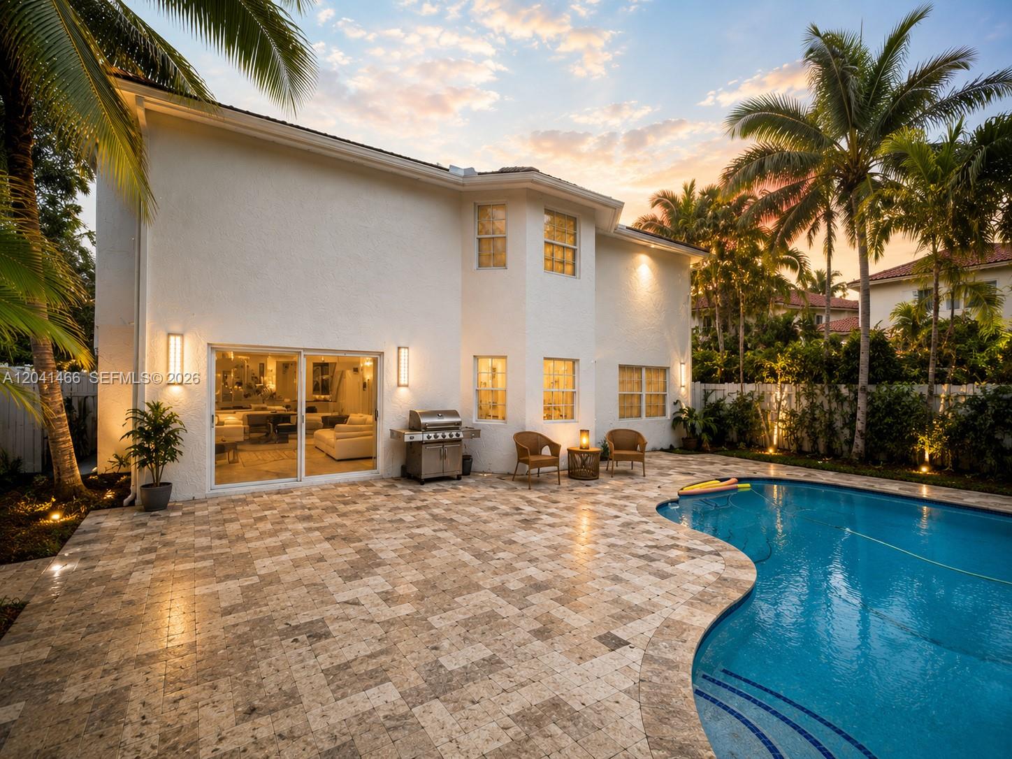 A two-story white house features a patio with a pool and a built-in grill — 85 Gables Blvd, Weston FL 33326, WESTON, FL