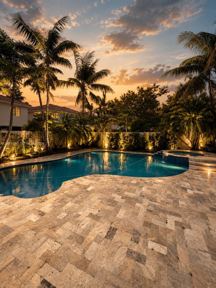 A backyard swimming pool with a spa and stone patio surrounded by palm trees — 85 Gables Blvd, Weston FL 33326, WESTON, FL