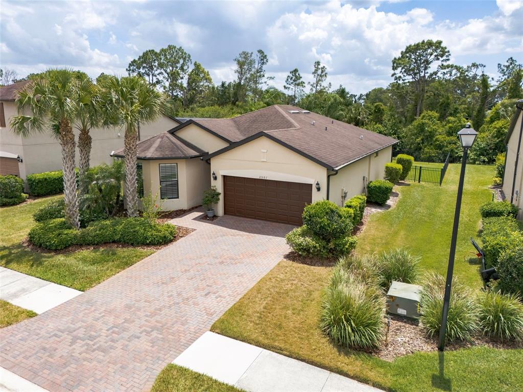 An exterior view of a single-story house with a brick paver driveway and palm trees — 2501 SHERMAN OAK DRIVE, NORTH PORT, FL