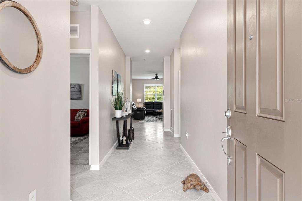 A tiled entryway leads into a hallway with a console table and living area beyond — 2501 SHERMAN OAK DRIVE, NORTH PORT, FL