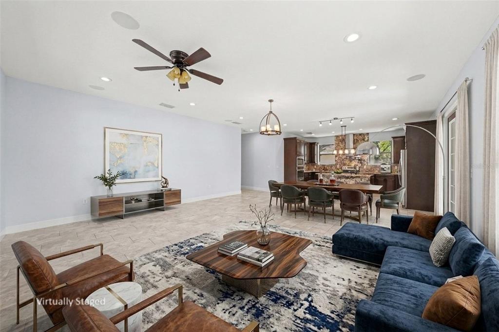 A virtually staged open-concept living and dining area with tile floors and dark wood cabinetry — 7110 N TALIAFERRO AVENUE, TAMPA, FL