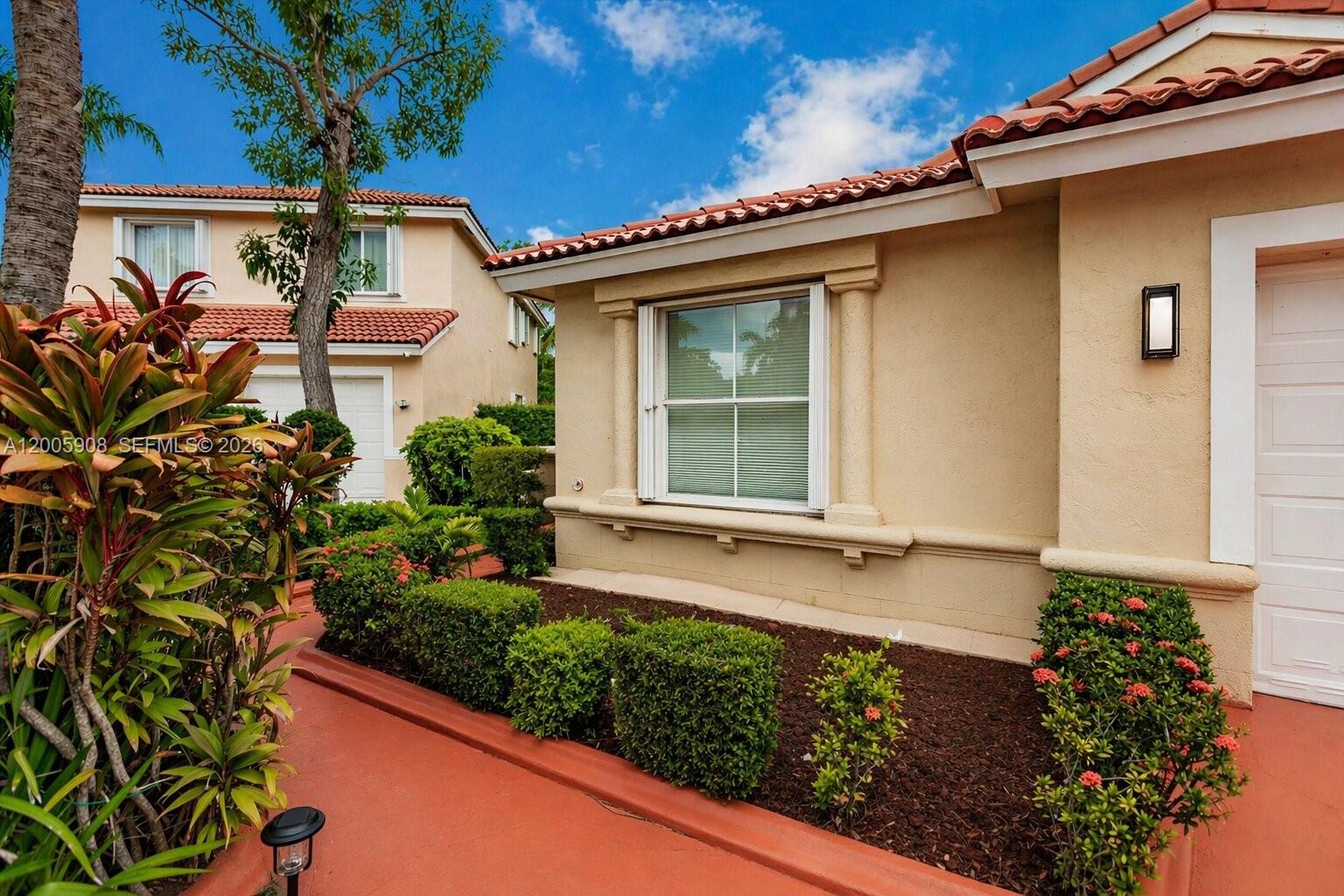 A beige stucco house exterior features a window with columns and a red tile roof — 6298 Harbour Chase Dr, Lake Worth FL 33467, LAKE WORTH, FL