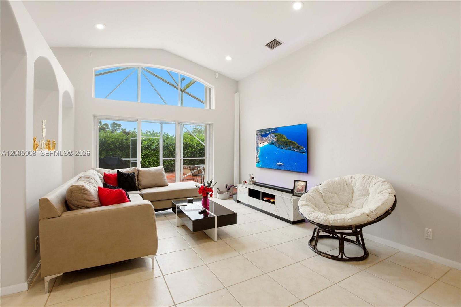 A living room features a vaulted ceiling, tile flooring, a sectional sofa, and a television — 6298 Harbour Chase Dr, Lake Worth FL 33467, LAKE WORTH, FL