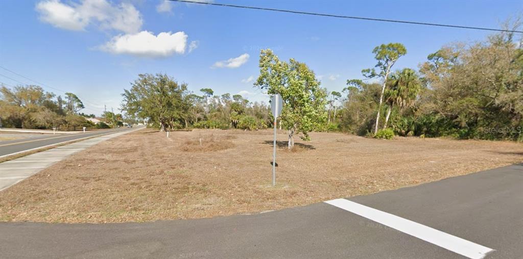 A vacant, grassy corner lot sits at the intersection of two paved roads — 16582 CAPE HORN BOULEVARD, PUNTA GORDA, FL