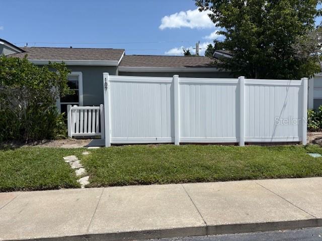 A white vinyl privacy fence stands in front of a house with a gray roof — 107 DORCHESTER SQUARE, LAKE MARY, FL